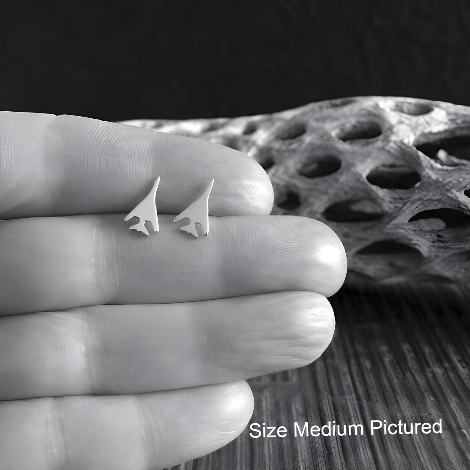 Pair of B-1 Lancer Military Jet Sterling Silver Stud Earrings held in a hand for size reference