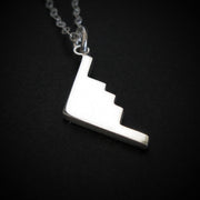 Silver B-2 Spirit Bomber Military Jet Pendant necklace on a dark background