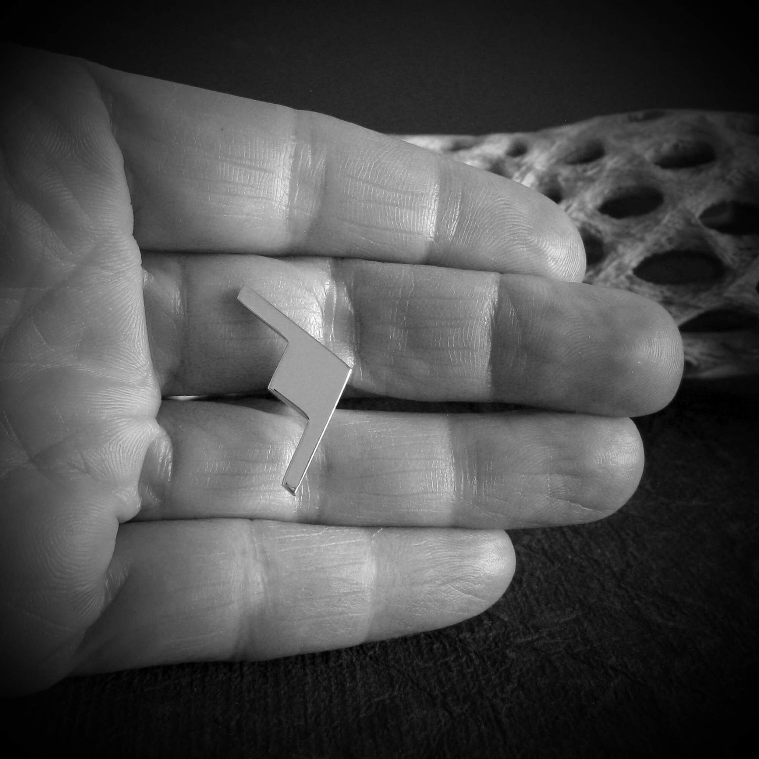 Handcrafted sterling silver B-21 Raider bomber jet cuff links displayed in artisan’s hand