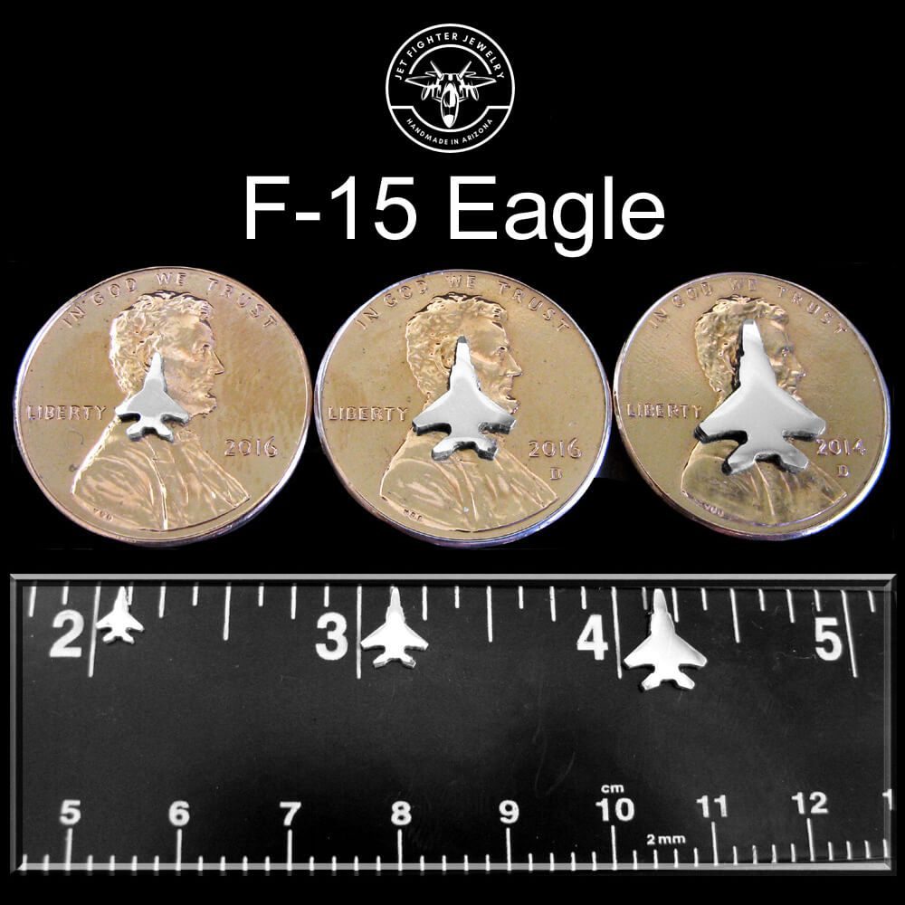 Silver silhouette of an F-15 Jet Fighter shown on a ruler and pennies for size reference for stud earrings