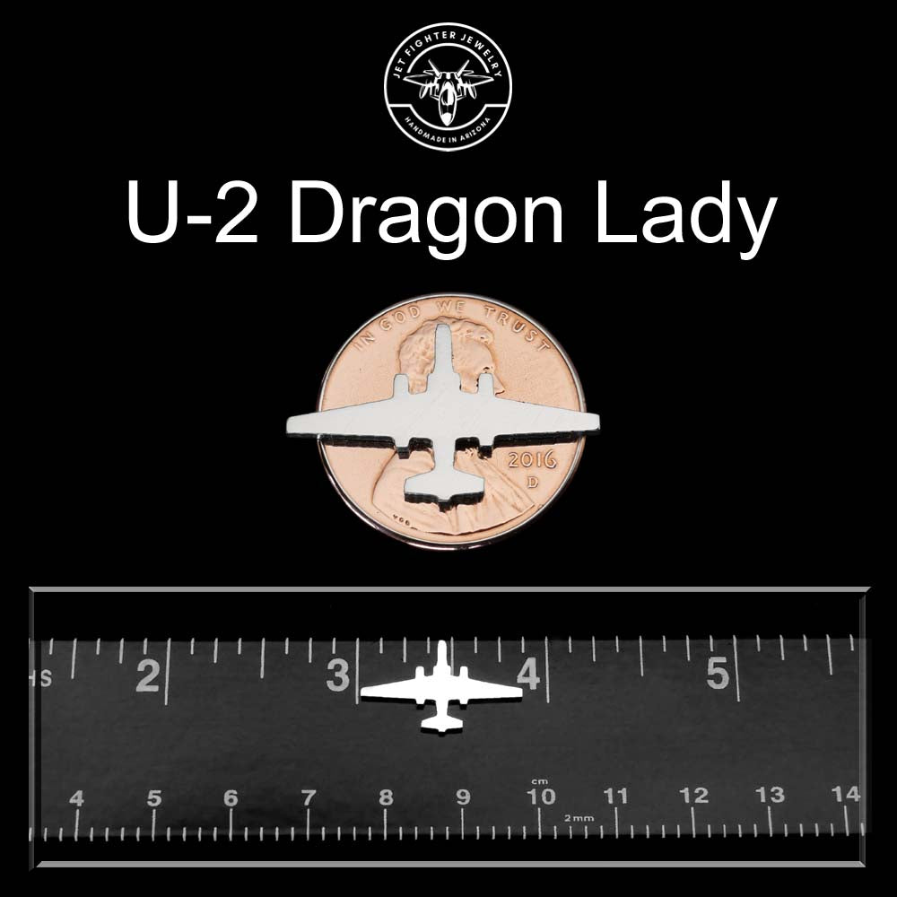 U-2 Dragon Lady airplane model on a penny with a ruler for scale against a black background.