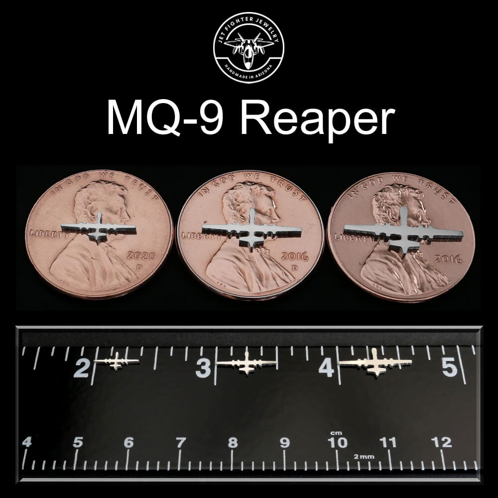 Three coins with MQ-9 Reaper design on a black background with a ruler for scale.