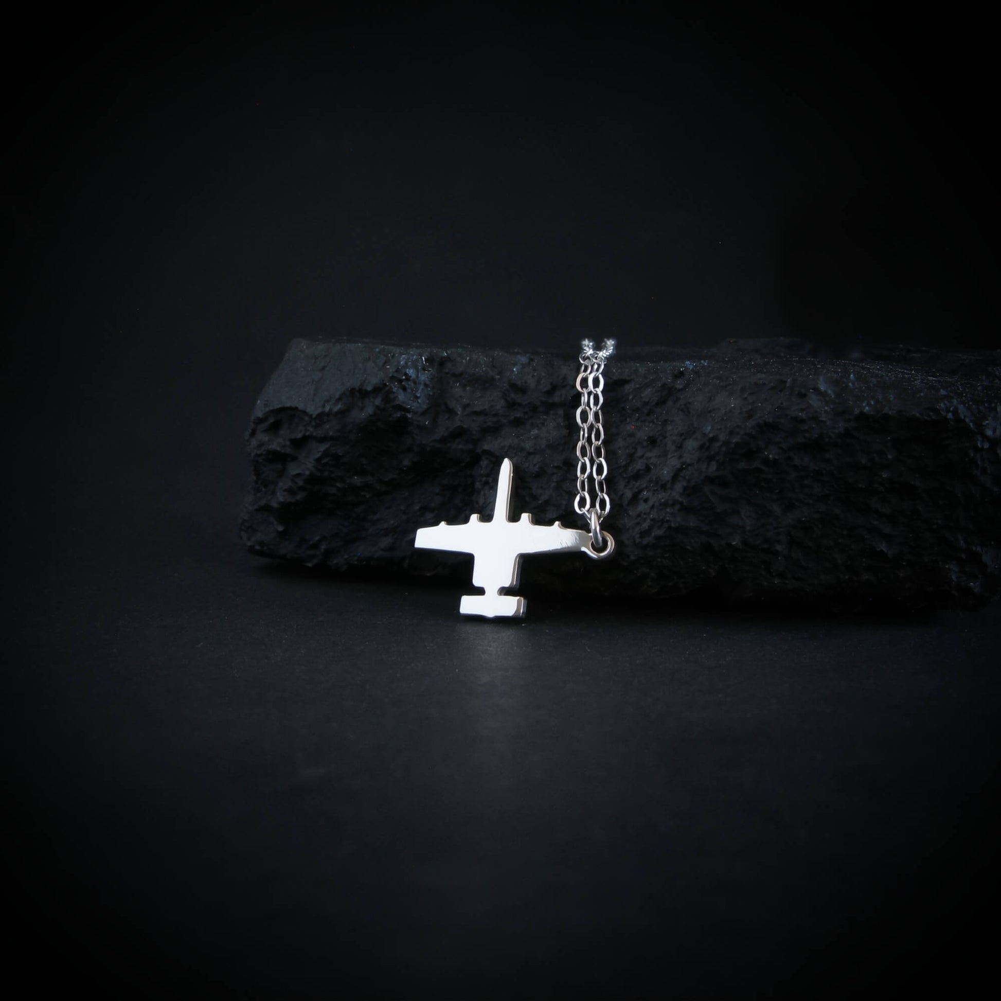 Sterling silver A-10 Warthog airplane pendant necklace displayed on black rock military aviation jewelry