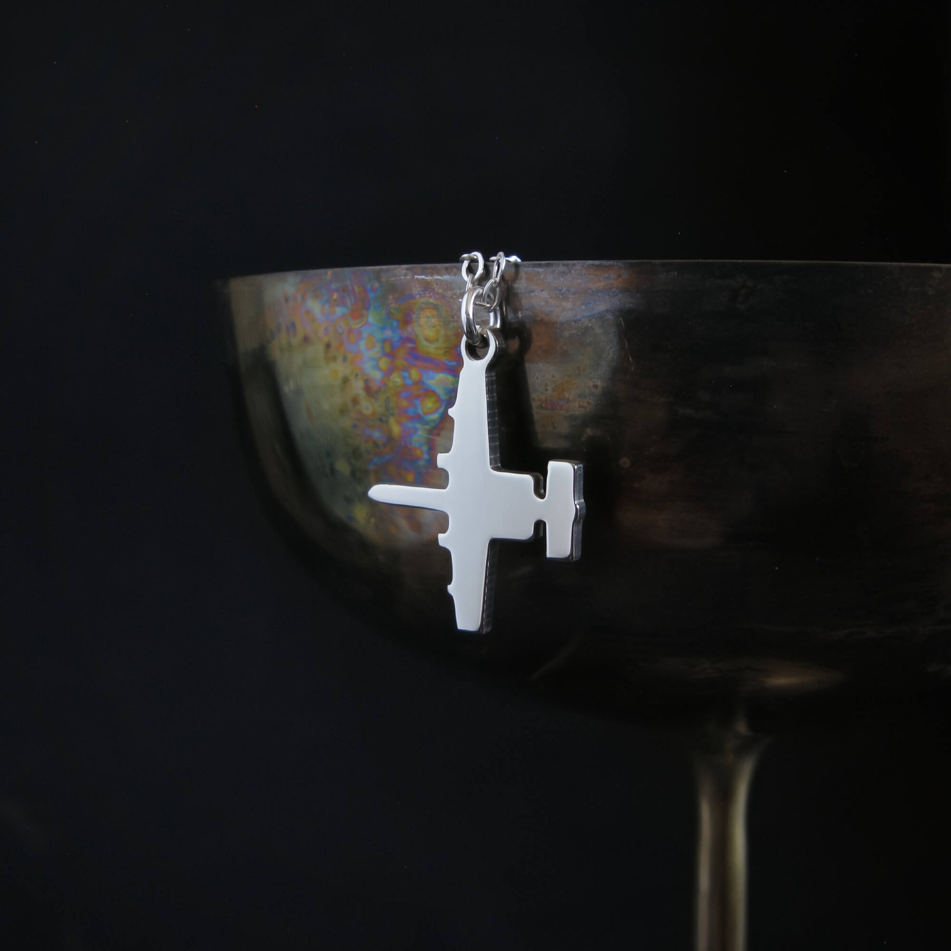 Sterling silver A-10 Warthog military aircraft pendant necklace draped on wine goblet aviation jewelry