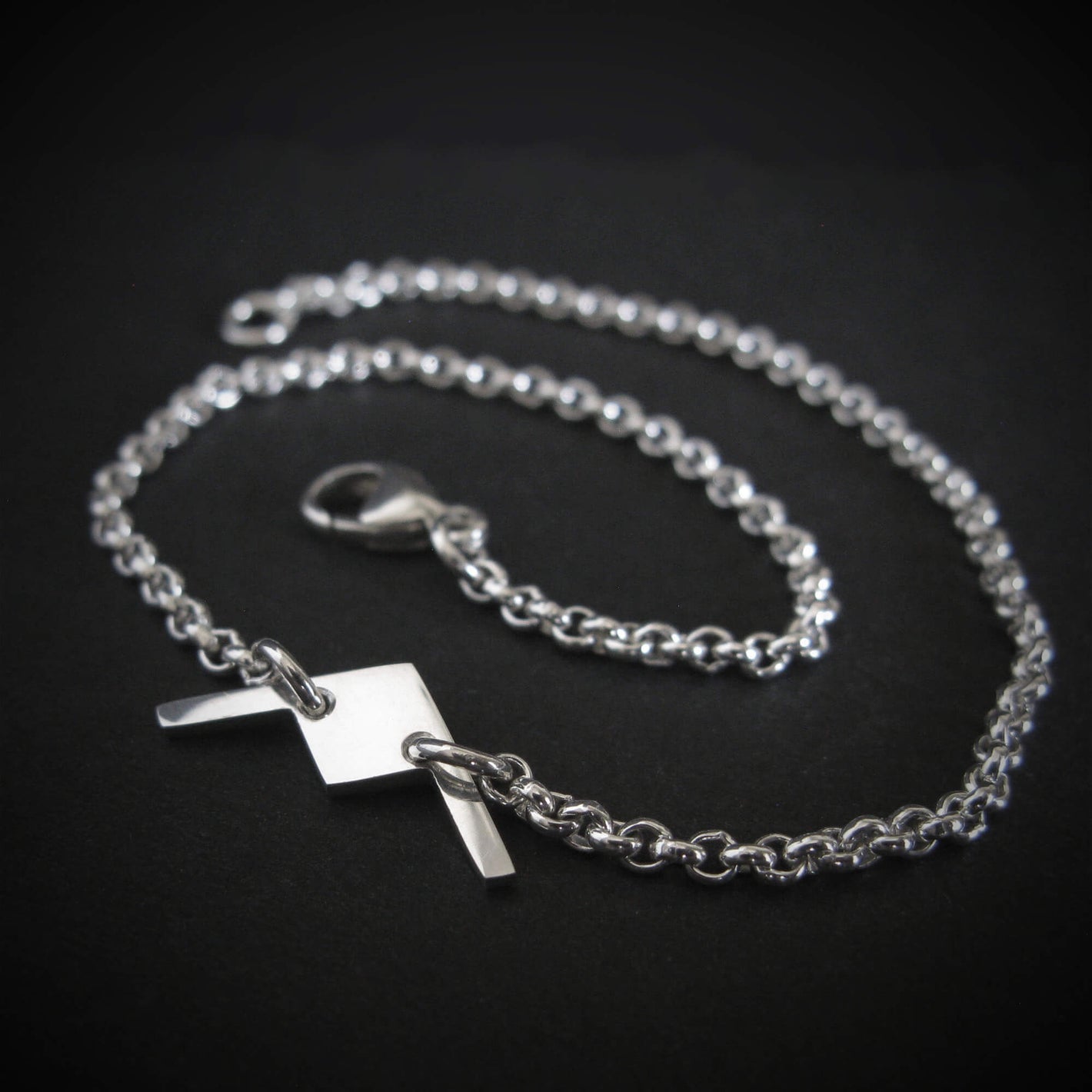 Close-up of sterling silver B-21 Raider bomber bracelet on dark background