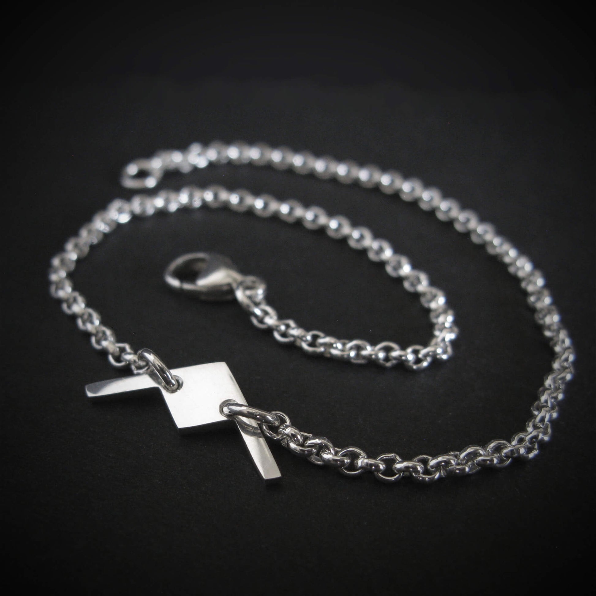 Close-up of sterling silver B-21 Raider bomber bracelet on dark background
