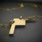 Handmade 14k gold B-21 Raider bomber jet pendant necklace displayed on dark background
