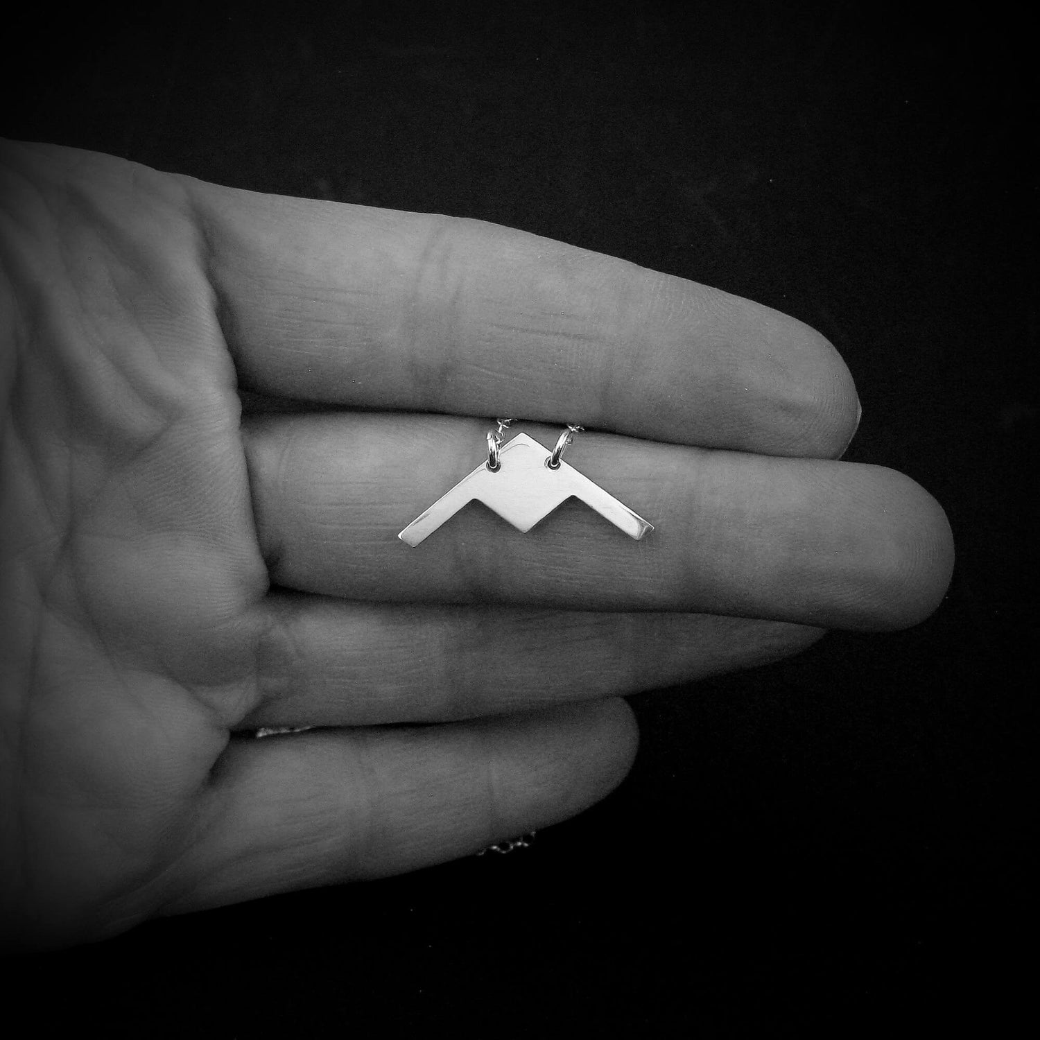 Sterling silver B-21 Raider stealth bomber pendant necklace held in hand by Jet Fighter Jewelry