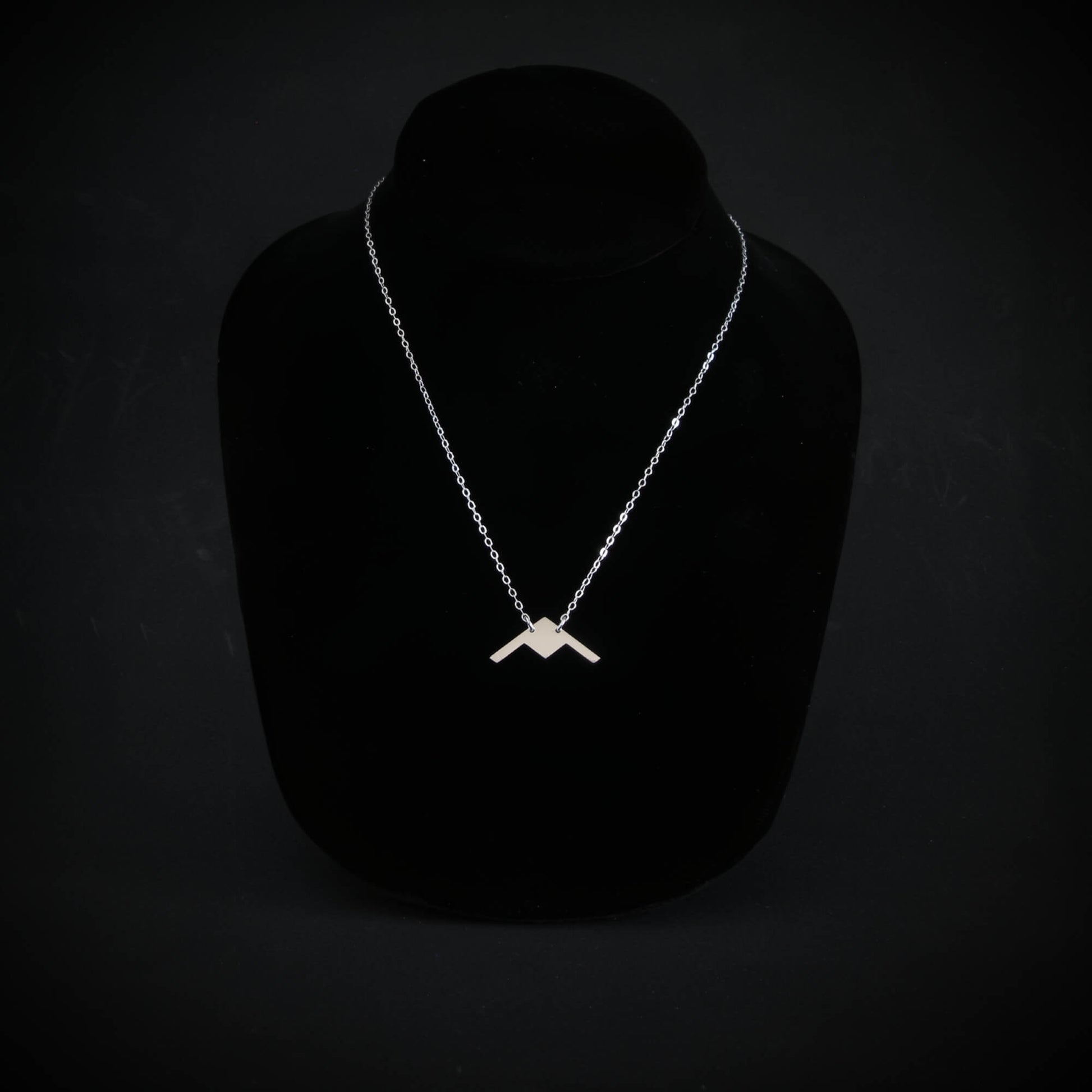 Sterling silver B-21 Raider stealth bomber pendant necklace on display bust by Jet Fighter Jewelry