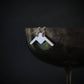 Handmade sterling silver B-21 Raider bomber jet pendant displayed on metallic goblet