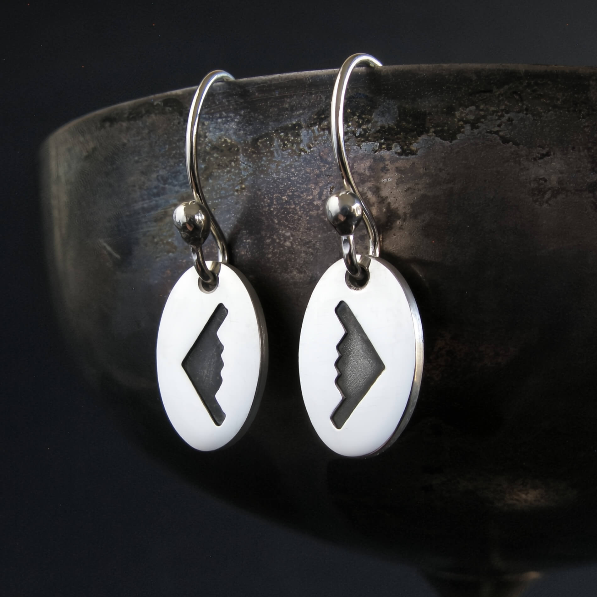 sterling silver B‑2 Spirit bomber airplane dangle earrings displayed on artistic background – handmade aviation jewelry
