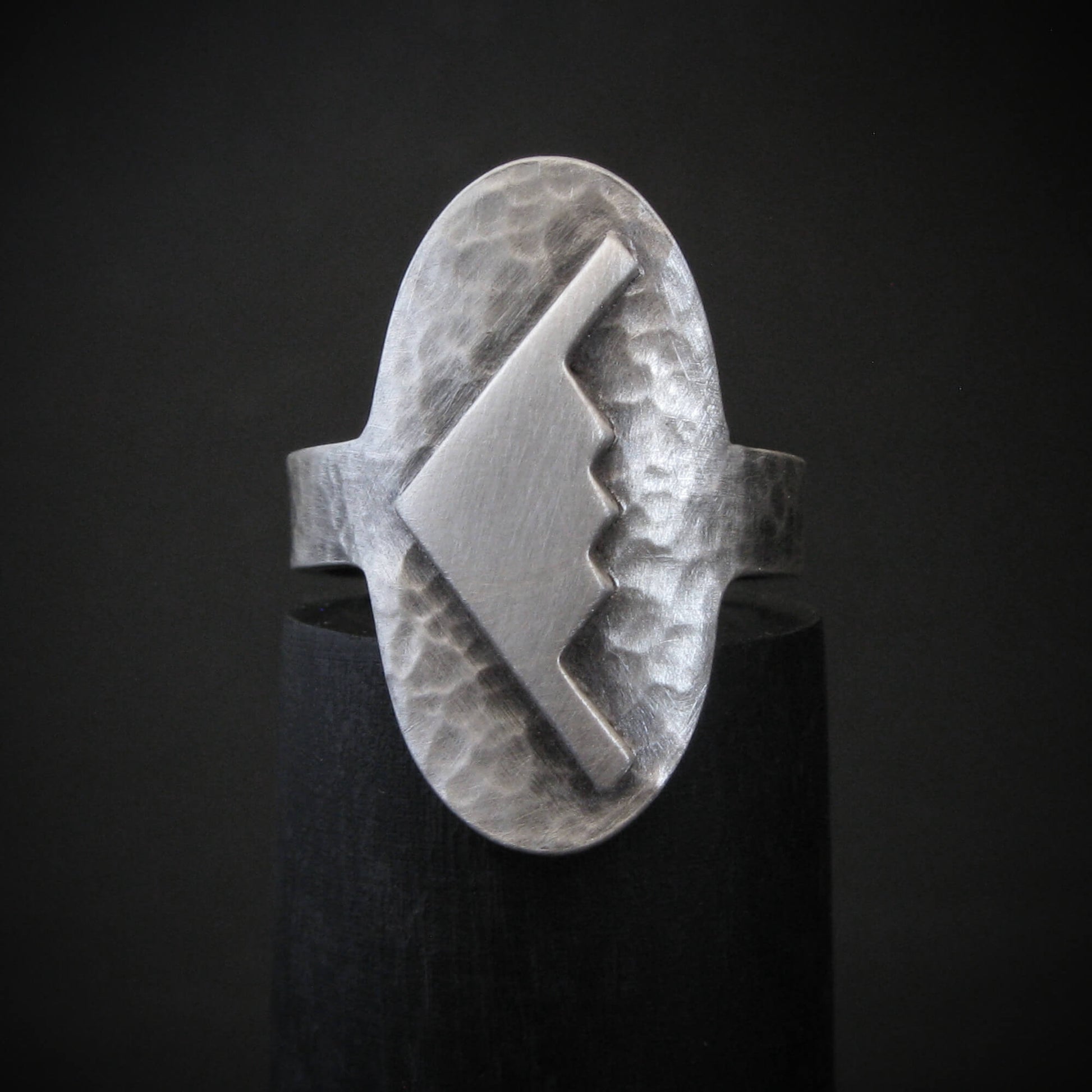 Hammered silver oval ring with a raised B-2 Bomber Military Aviation Jet silhouette on a black background