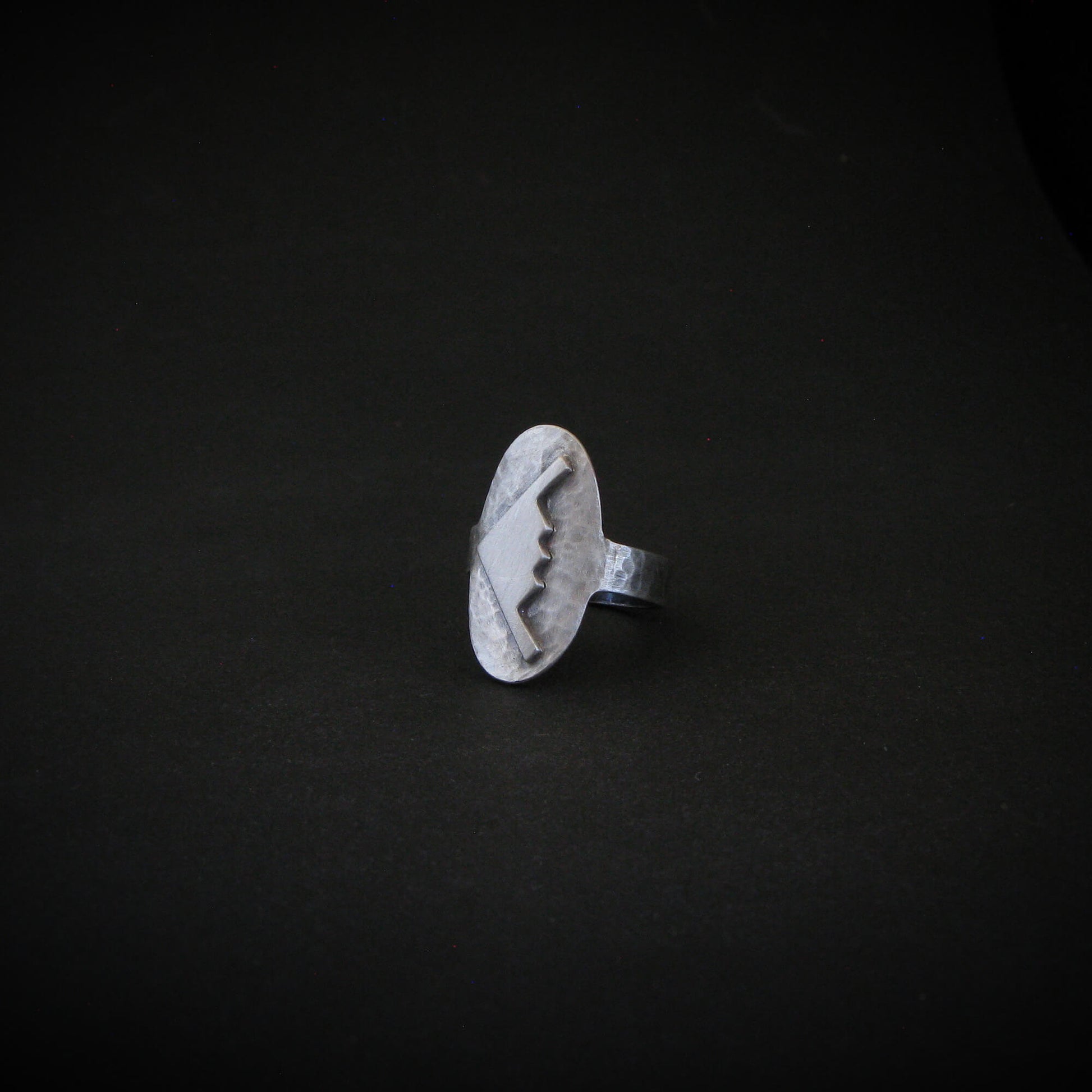 Hammered silver oval ring with a raised B-2 Bomber Military Aviation Jet silhouette on a black background