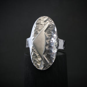Hammered silver oval ring with a raised B-2 Bomber Military Aviation Jet silhouette on a black background