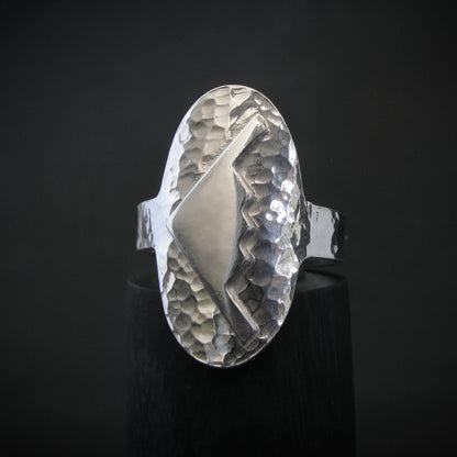 Hammered silver oval ring with a raised B-2 Bomber Military Aviation Jet silhouette on a black background