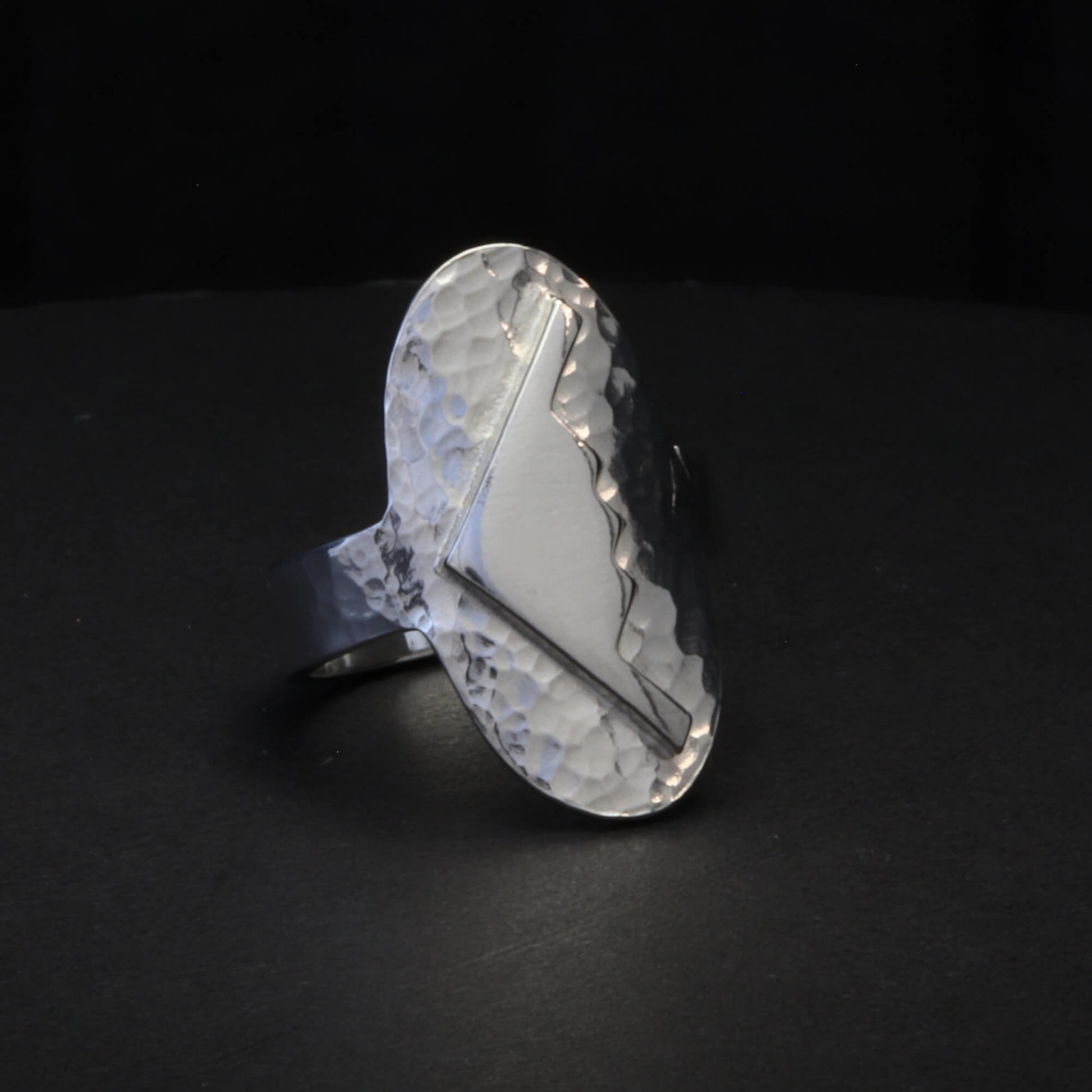 Hammered silver oval ring with a raised B-2 Bomber Military Aviation Jet silhouette on a black background