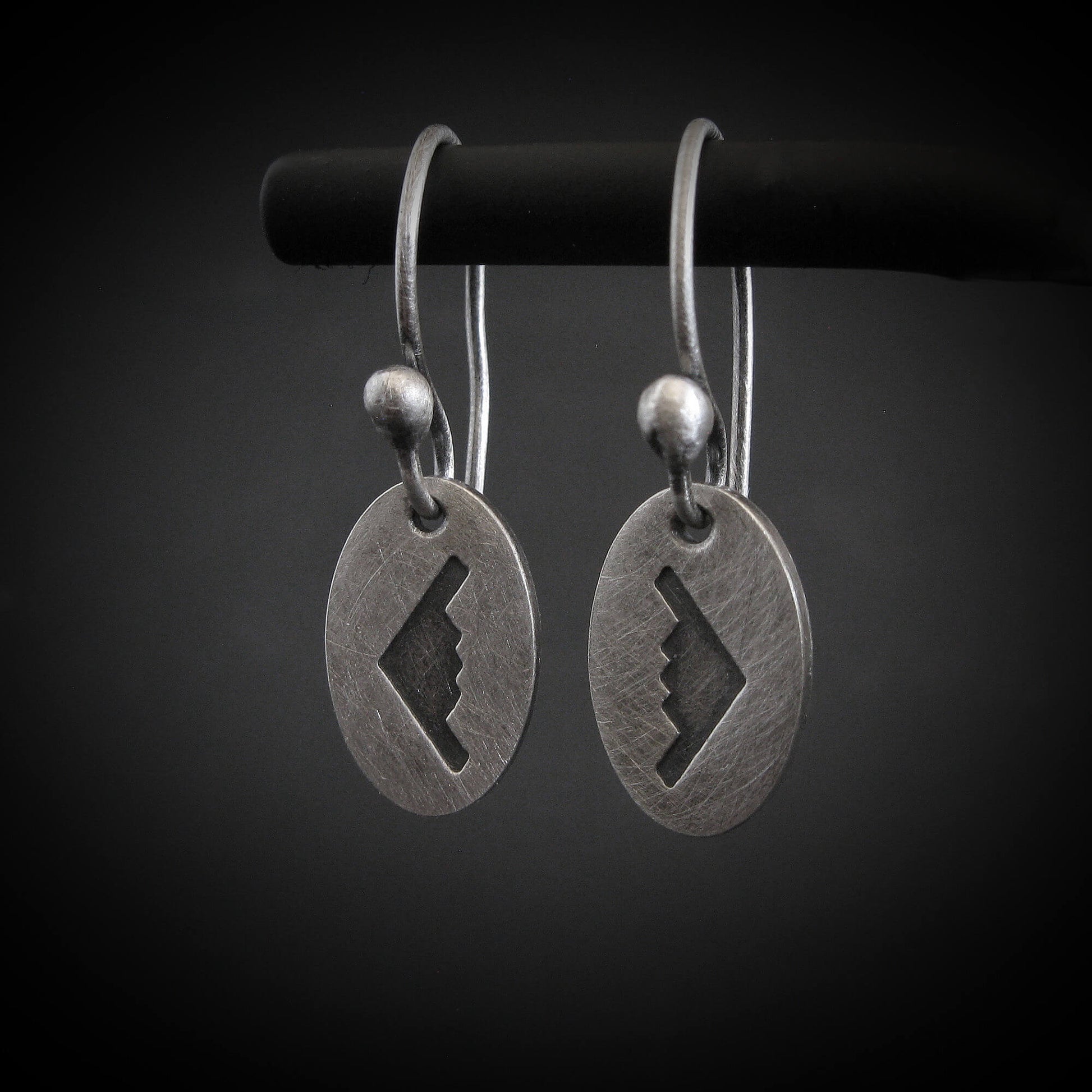 Antiqued sterling silver B‑2 Spirit bomber airplane dangle earrings on black background – handmade military aviation jewelry