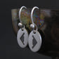 Satin sterling silver B‑2 Spirit bomber airplane dangle earrings displayed on artistic background – handmade military aviation jewelry