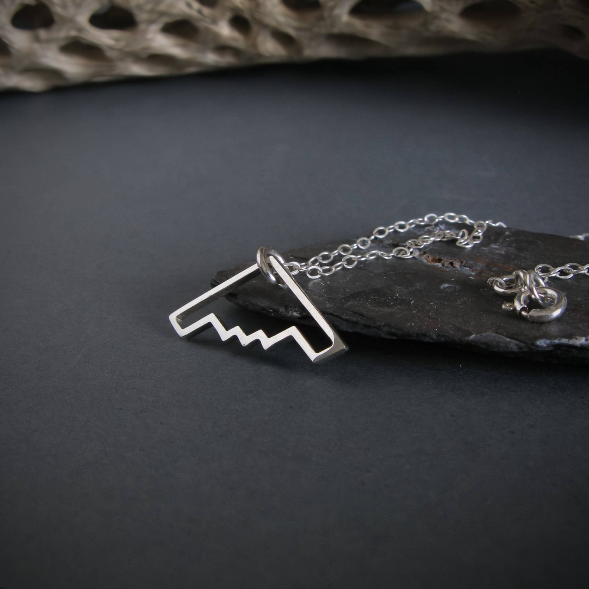 Sterling silver B‑2 Spirit bomber airplane outline pendant necklace on chain – handmade aviation jewelry displayed on slate background