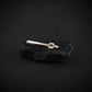 Sterling silver B-2 Spirit Bomber tie bar displayed on black volcanic stone with engraved aircraft detail