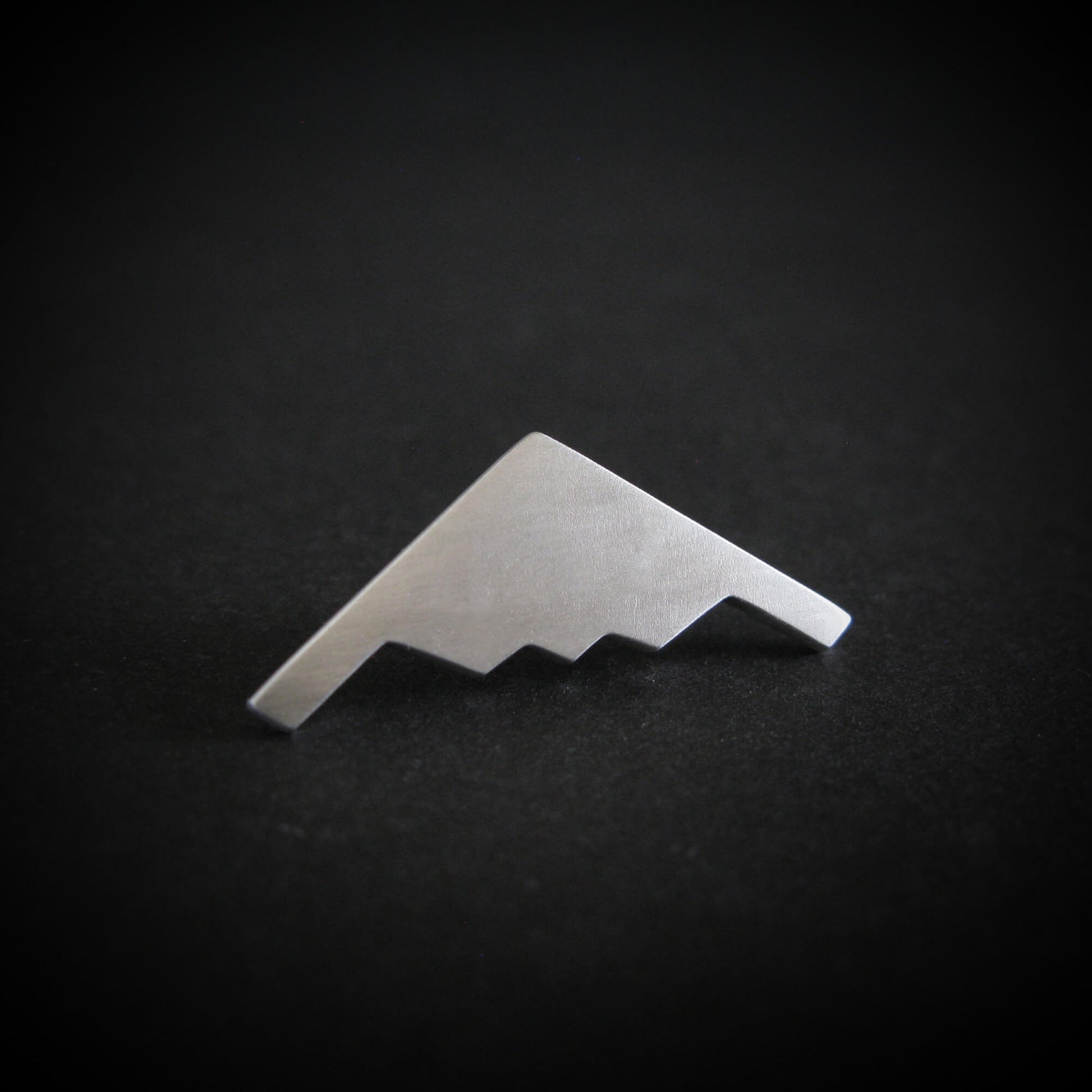 Silver B-2 Spirit Bomber military fighter jet airplane tie tack on a black background
