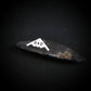 B-2 stealth bomber tie tack with "DAD" engraving in sterling silver, styled on dark gray stone background, handcrafted aviation jewelry gift