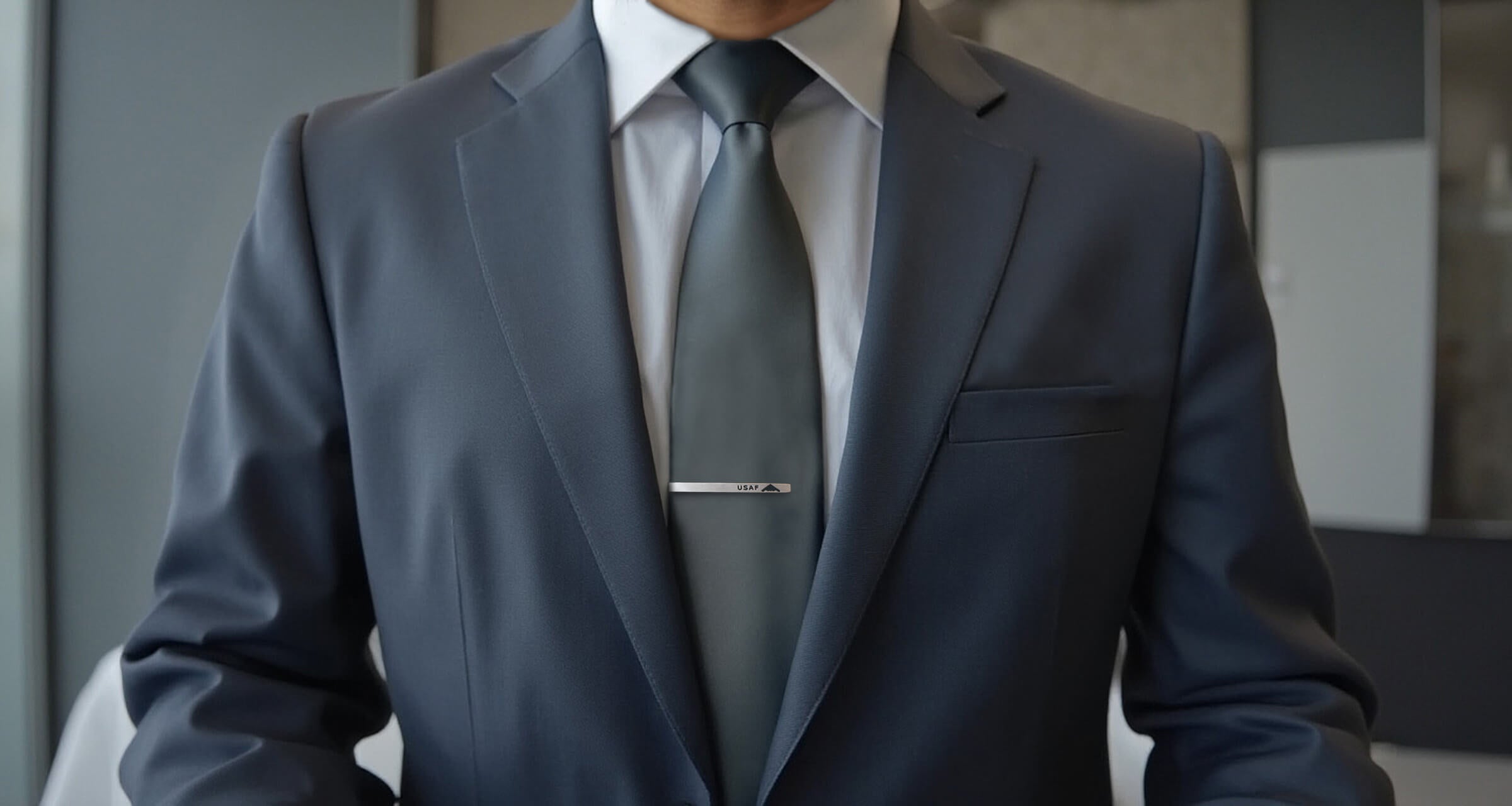 Torso close up of a man in a suit and tie with a silver USAF Tie Bar