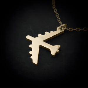 Gold B-52 Bomber pendant on a chain against a black background 