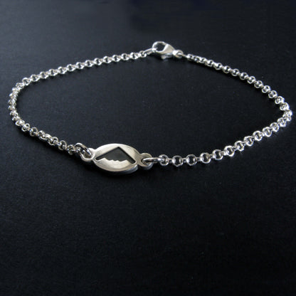 Dainty Sterling Silver bracelet with a B-2 Spirit silhouette charm on a black background