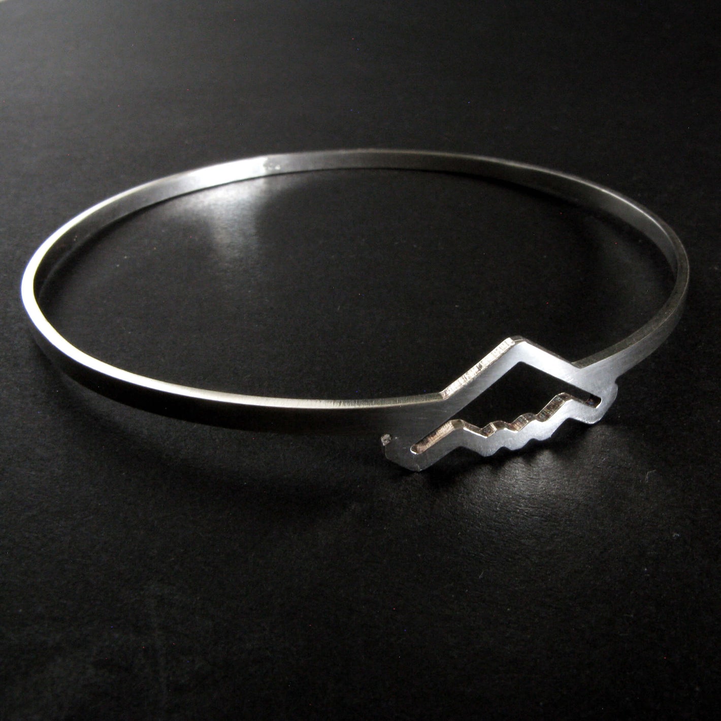 Silver bangle bracelet with B-2 Bomber Military Jet on a dark background