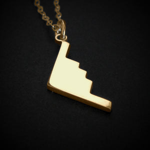14k Gold B-2 Spirit Bomber Military Jet Pendant necklace on a dark background