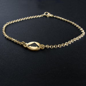 Gold B2 Spirit Bomber charm bracelet on a dark background