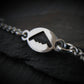 B-2 Sterling Silver dainty charm bracelet on a dark rock