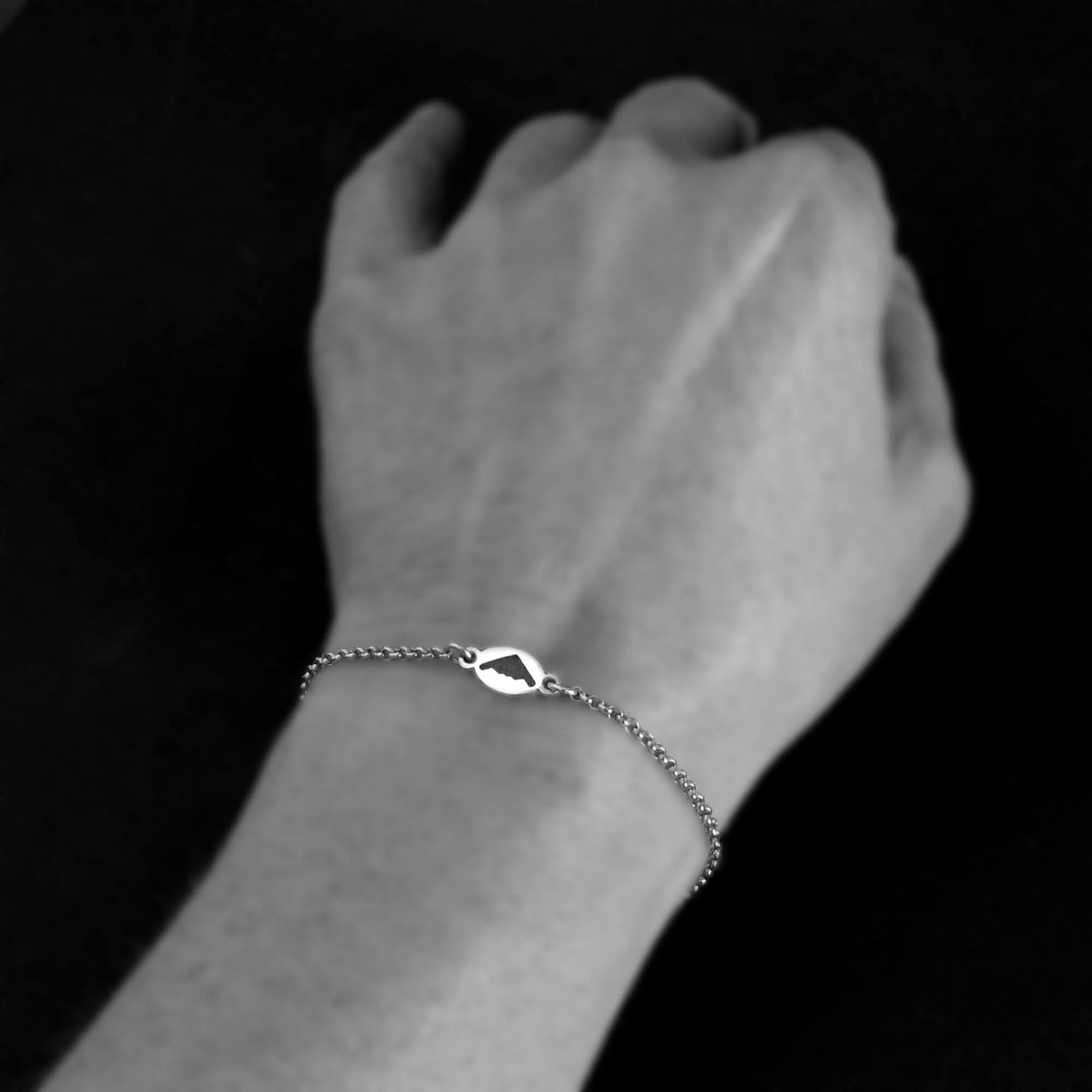 Silver B-2 Spirit Bomber Military jet bracelet on a wrist against a black background