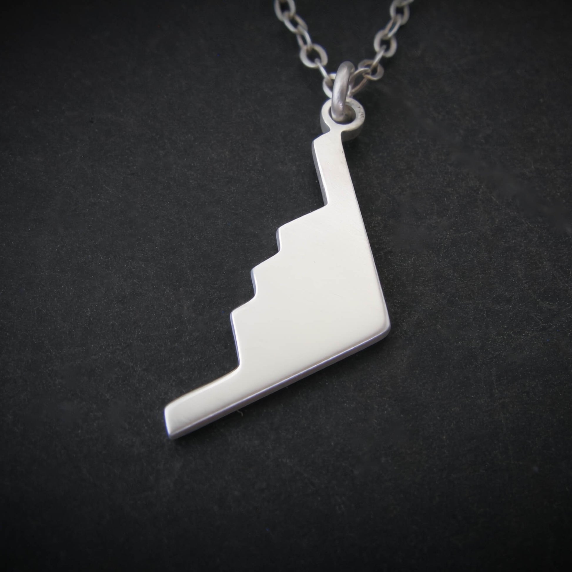 Silver B-2 Spirit Bomber Military Jet necklace pendant on a black background