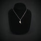 Silver B-2 Spirit Bomber Military Jet necklace with a pendant on a black mannequin against a dark background