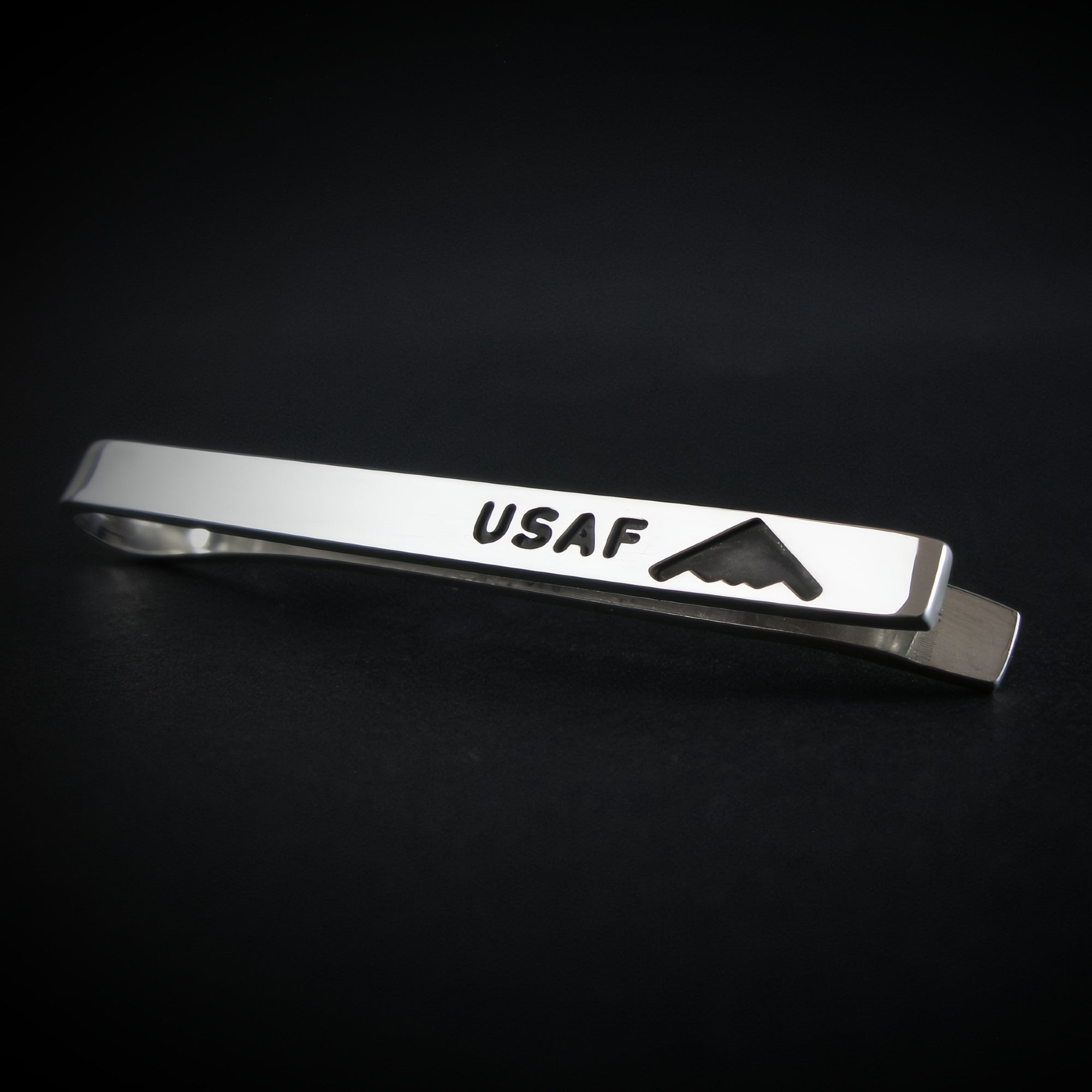 USAF Sterling Silver Tie Bar with engraved B-2 Spirit Bomber shown at an angle on a black background