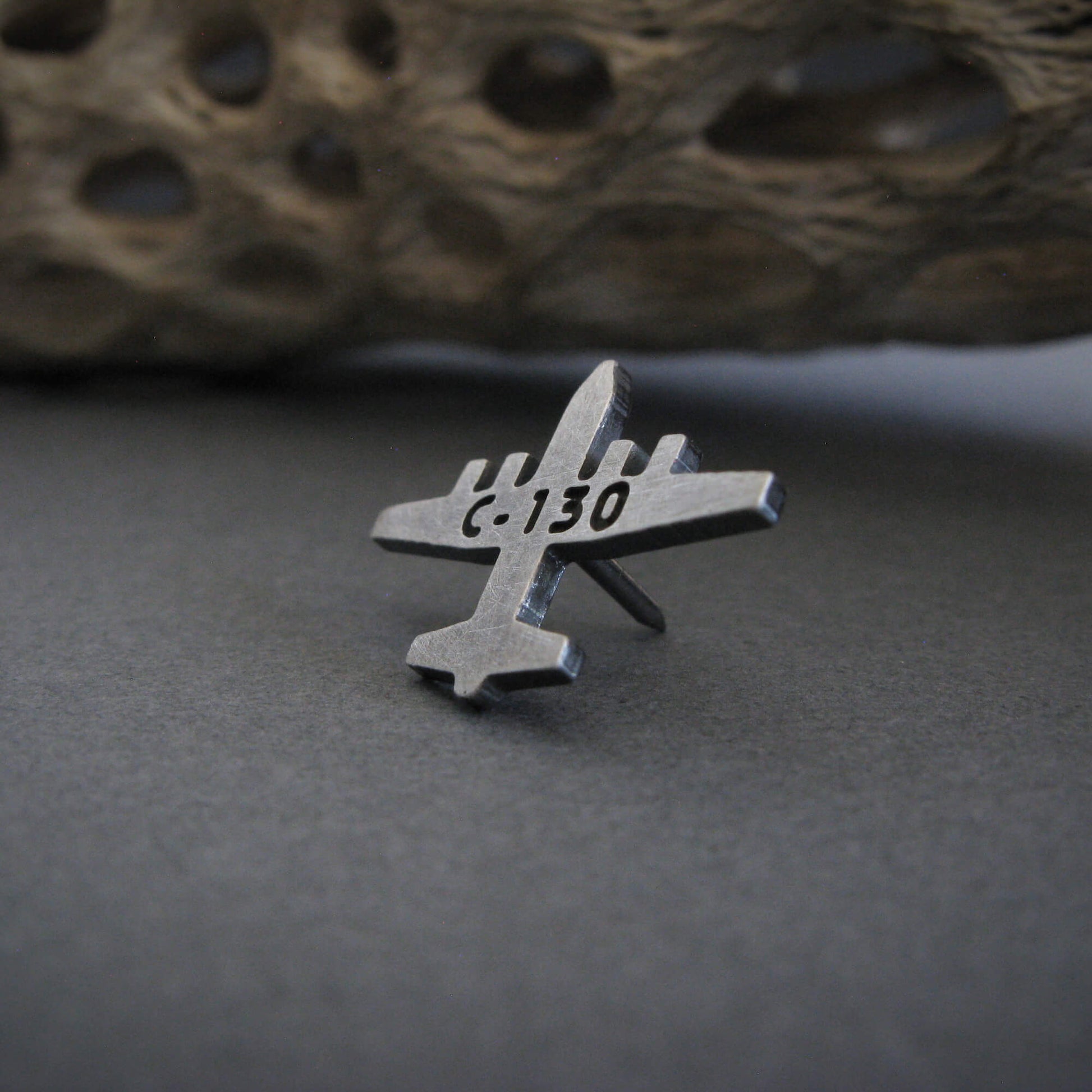 Antiqued sterling silver C-130 Hercules airplane tie tack with engraved text on gray background – handcrafted aviation jewelry