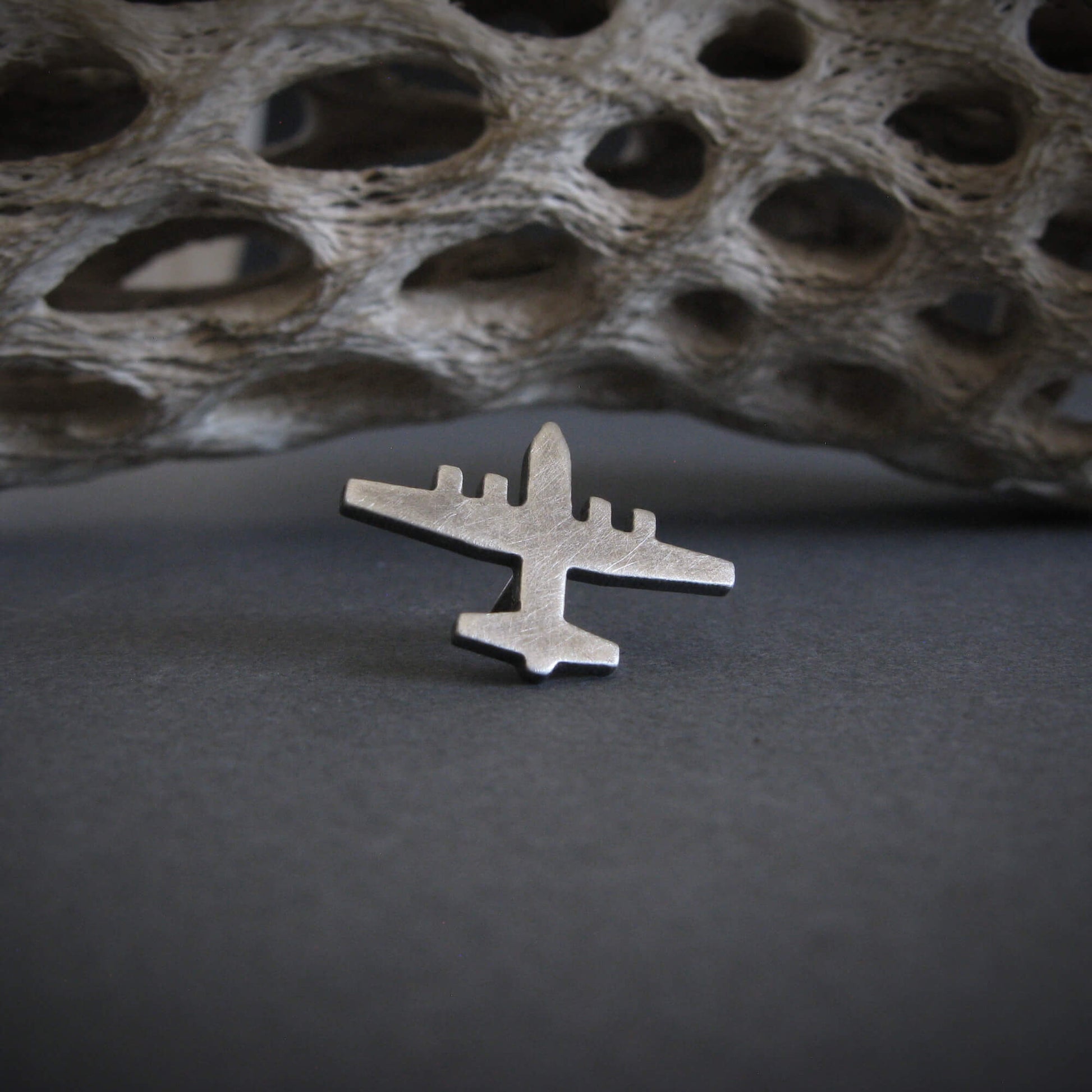 Antiqued sterling silver C-130 Hercules airplane tie tack on gray artistic background – handcrafted pilot gift