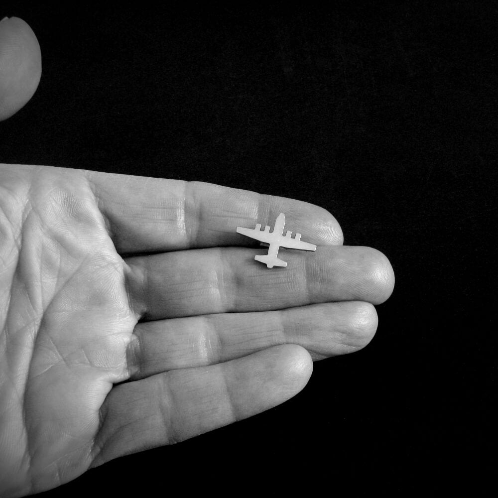 Handmade sterling silver C-130 Hercules airplane tie tack shown in hand for size – military aviation accessory for pilots and veterans
