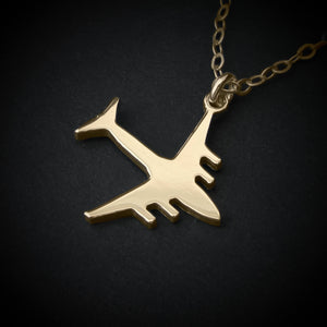 C-17 Globemaster military airplane pendant necklace in polished 14k gold, shown close-up against a dark background.