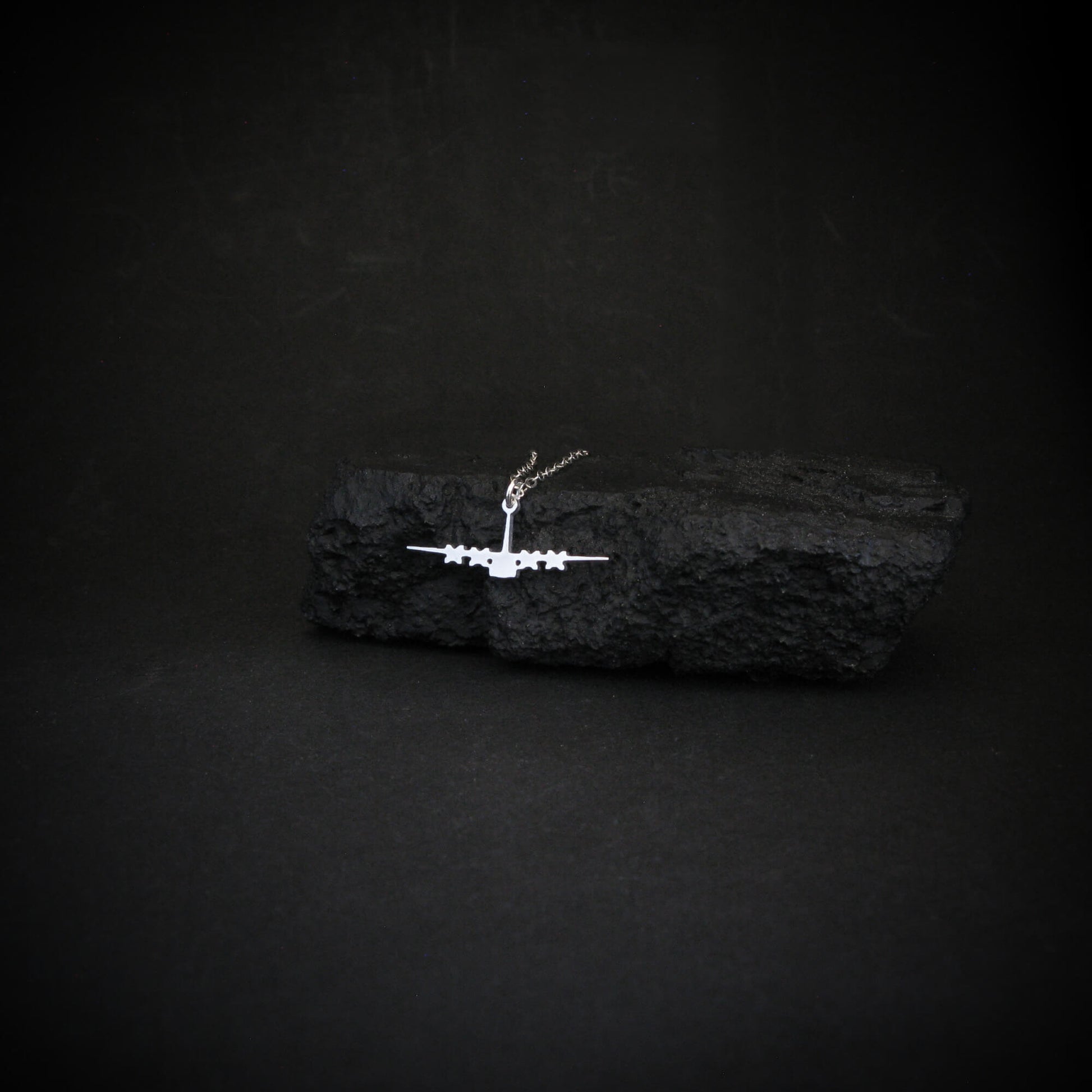 Sterling silver C-130 Hercules necklace styled on black rock