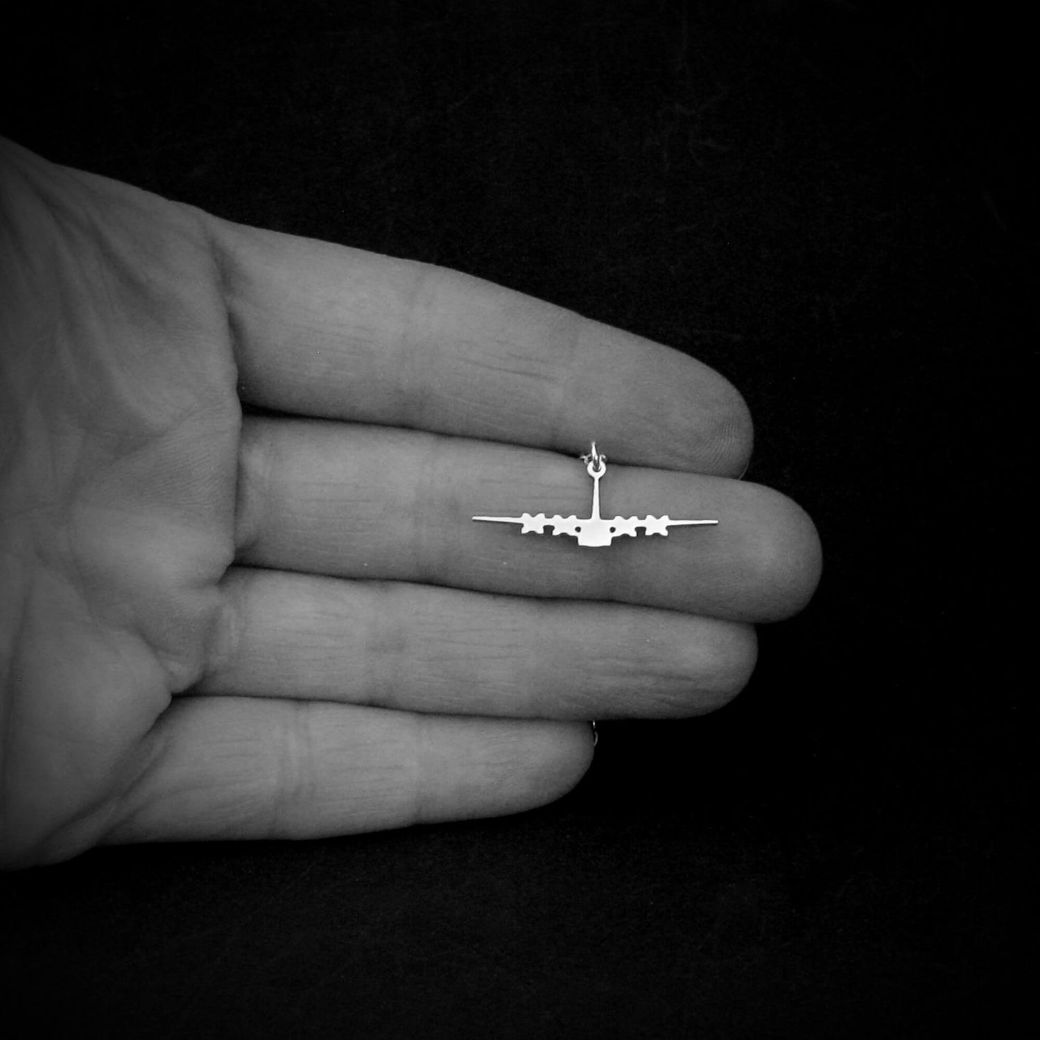 Sterling silver C-130 silhouette necklace shown in hand for size reference