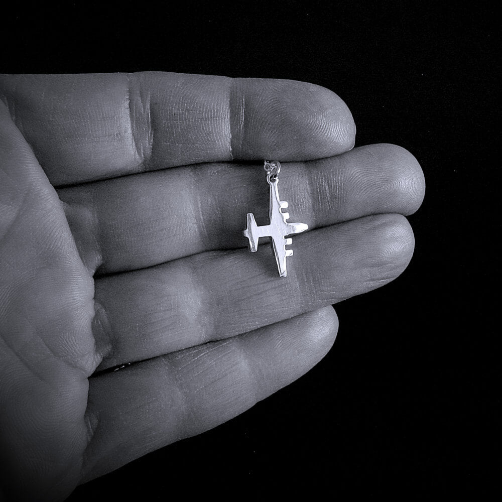 Sterling Silver C-130 airplane pendant made by Jet Fighter Jewelry held in a hand against a black background