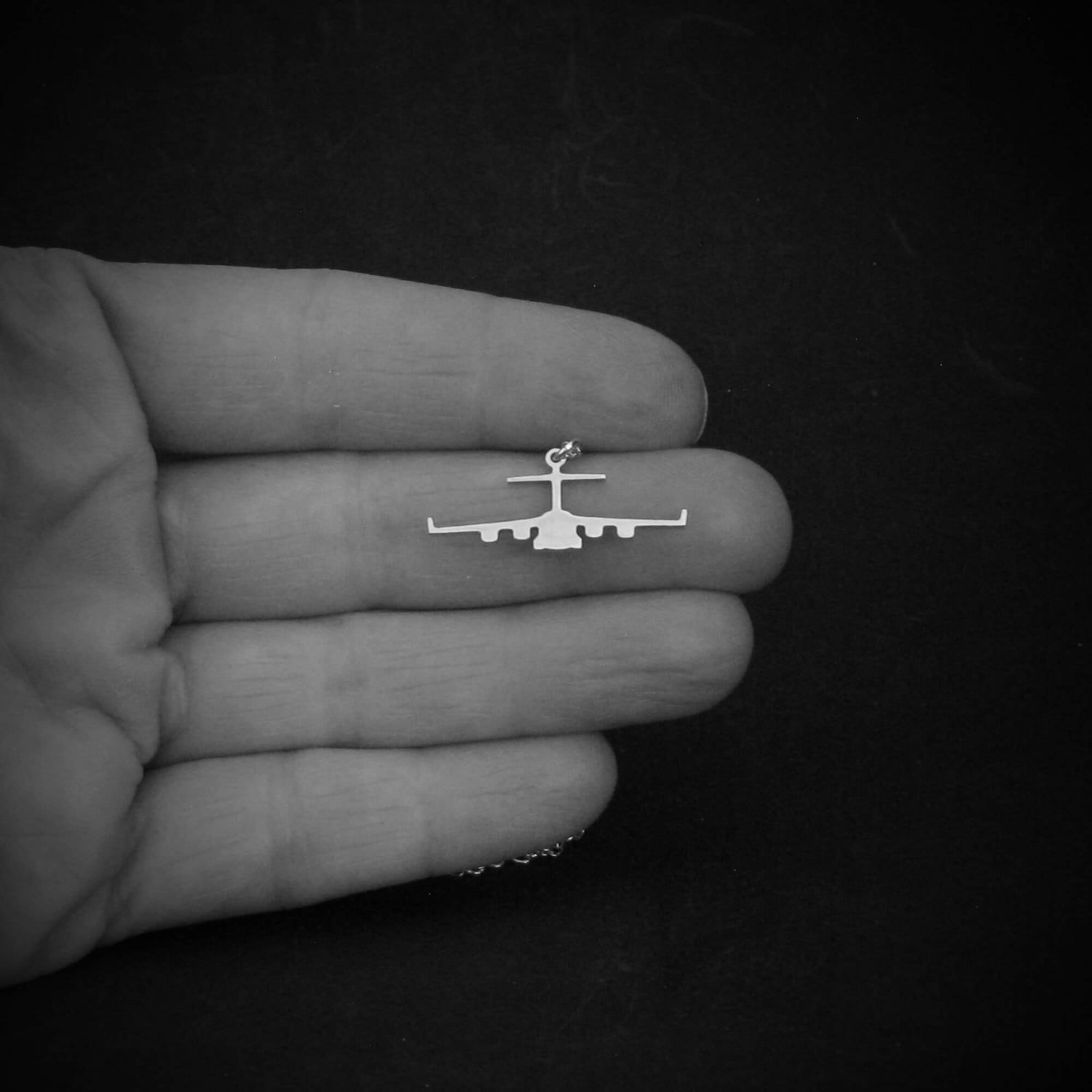 Sterling silver C-17 Globemaster necklace held in hand to show scale of front silhouette pendant