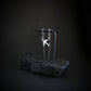 Sterling silver C-17 silhouette pendant hanging on black rock