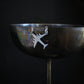Military aircraft necklace hanging from wine glass edge