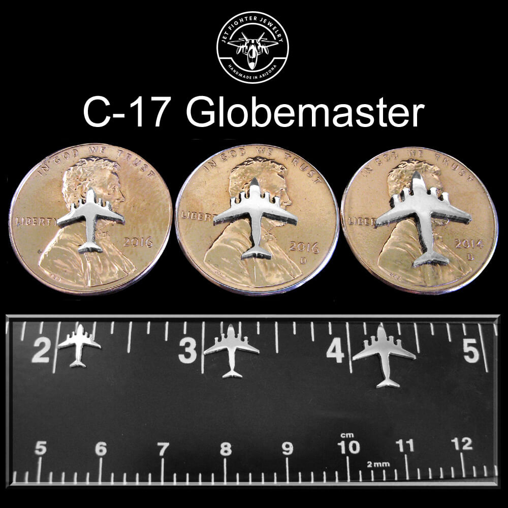Silver silhouette of a C-17 Military Jet Fighter shown on a ruler and pennies in three different sizes