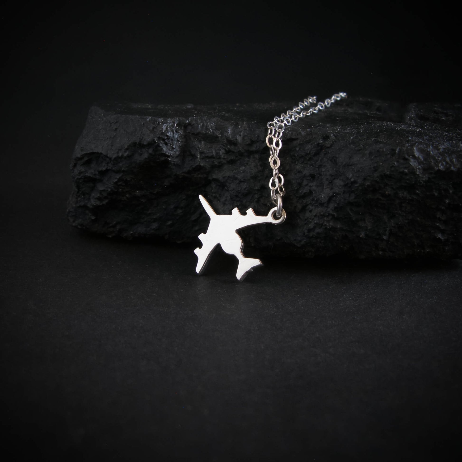 Sterling silver E-3 Sentry AWACS airplane pendant necklace displayed on black rock aviation jewelry