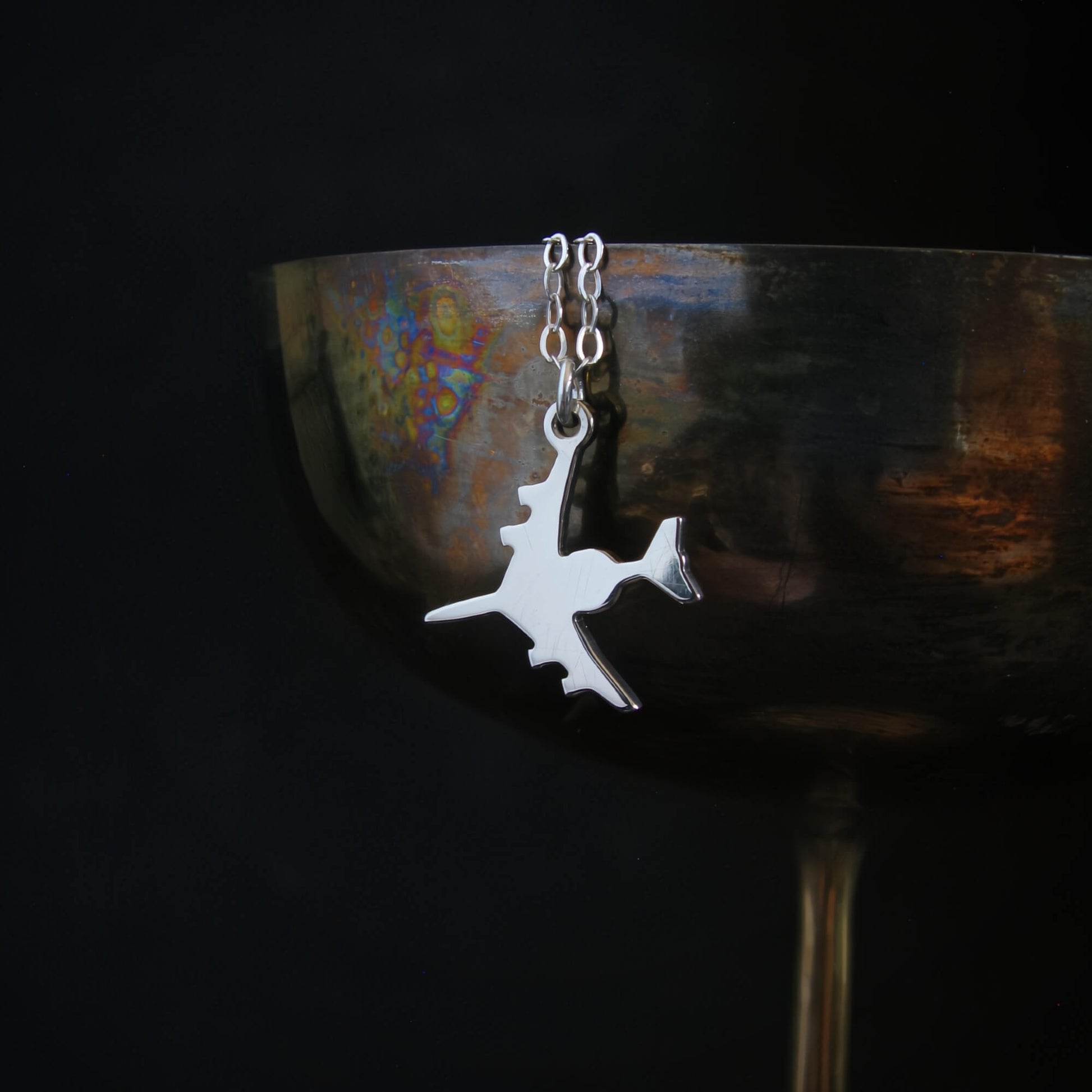 Sterling silver E-3 Sentry AWACS aircraft pendant necklace draped on wine goblet military aviation jewelry